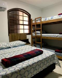 1 Schlafzimmer mit 2 Etagenbetten und 1 Bett mit einer Decke in der Unterkunft Apartamento Praia do Bonfim in Angra dos Reis