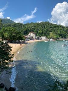 a beach with a bunch of people in the water at Apartamento Praia do Bonfim in Angra dos Reis