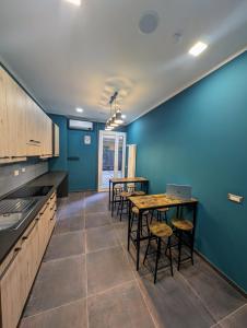 eine Küche mit blauen Wänden sowie einem Tisch und Stühlen in der Unterkunft Benedict Rooms in Bologna