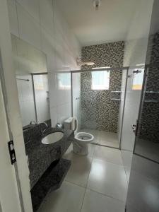 uma casa de banho com um WC, um lavatório e um chuveiro em Apto Aconchego Capitólio em Capitólio