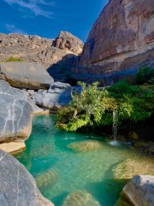 uma piscina de água num desfiladeiro com pedras em Jebel shams Sky em Misfāh