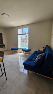 a living room with a blue couch and a window at Recanto na beira da praia in Caraguatatuba