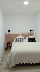a white bedroom with a bed with two pillows at Apartamento da Torre in Guarda