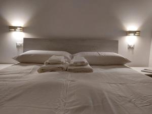 Una gran cama blanca con toallas encima. en l'aira ecchia - ospitalità rurale, en Lecce
