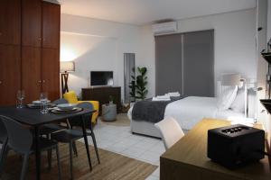 Habitación de hotel con cama, mesa y sillas en Happy Place Home # 1, en Volos