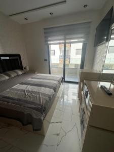 una camera da letto con un letto e una grande finestra di Martil dream with private garage a Martil