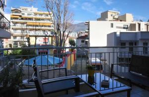 balcón con mesa y vistas a la piscina en Happy Place Home # 1, en Volos