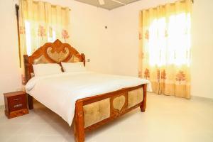 - une chambre avec un grand lit et une tête de lit en bois dans l'établissement Bali Luxury Apartments Diani, à Ukunda