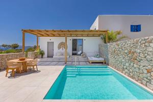 a villa with a swimming pool and a patio at Milos Villas Complex in Pefki