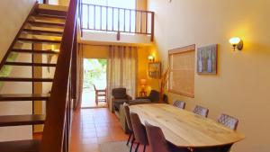 拉貢的住宿－Lagun Blou Resort，一间带木桌和楼梯的用餐室