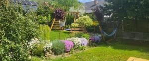 einen Garten mit Schaukel und Blumen im Hof in der Unterkunft Cichy Zakątek in Uście Gorlickie