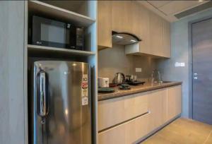 een keuken met een roestvrijstalen koelkast en een magnetron bij Luxury Apartment In Gurgaon in Gurgaon