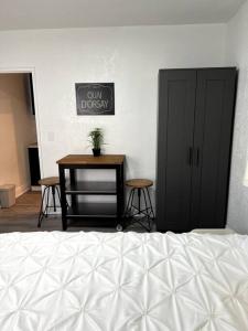 1 dormitorio con cama y mesa con taburetes en Nice and Cozy guest house en Miami