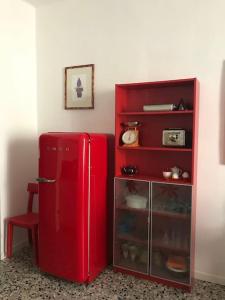 einen roten Kühlschrank in einem Zimmer mit einem roten Regal in der Unterkunft I Marici in Pavia