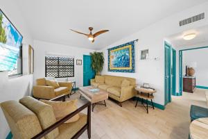 a living room with two couches and a table at Uptown Cottage - Walk to the Beach and Restaurants in Cocoa Beach