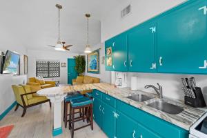 a kitchen with blue cabinets and a counter top at Uptown Cottage - Walk to the Beach and Restaurants in Cocoa Beach