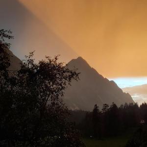 einen Blick auf einen Berg mit einem Regenbogen im Himmel in der Unterkunft Haus am Lärchenhang, Fewo5 in Leutasch