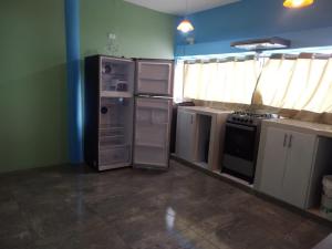 una cocina con nevera y otros electrodomésticos. en Balcones de Zorritos, en Bocapán
