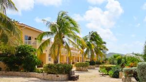 a building with palm trees in front of it at Lagun Blou Resort in Lagun