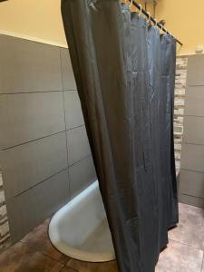 a shower with a black shower curtain in a bathroom at Apartamento para 8 personas frente a la plaza principal Mercedes Uruguay in Mercedes