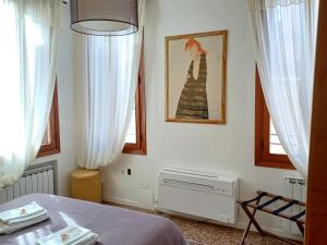 1 dormitorio con 1 cama y 2 ventanas en Fortuny Loft, en Venecia