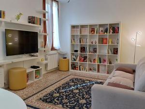 sala de estar con sofá, TV y estanterías de libros en Fortuny Loft, en Venecia