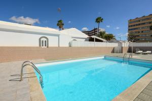 einem Pool mit blauem Wasser vor einem Gebäude in der Unterkunft Beachside hideaway Gran Canaria in San Bartolomé de Tirajana