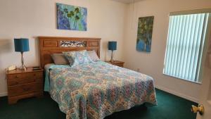 a bedroom with a bed and two lamps and a window at Orlando Mouse Manor in Davenport