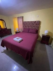 a bedroom with a large bed with a purple bedspread at Zayne's comfort zone in Hayes