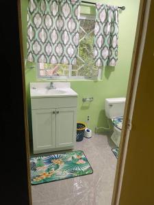 a bathroom with a sink and a toilet and a window at Zayne's comfort zone in Hayes