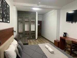 Dormitorio con cama, escritorio y TV en Hotel Sacha Golden, en Otavalo