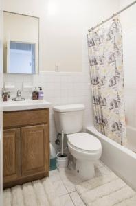 a bathroom with a toilet and a sink and a shower curtain at Amazing 3BR 1Bath Apartment in NYC! in New York