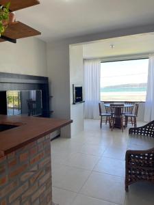 cocina y sala de estar con mesa y sillas en ponta do papagaio en Palhoça