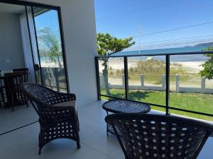 two chairs on a balcony with a view of the ocean at ponta do papagaio in Palhoça +20 photos