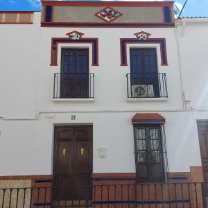 a white building with two doors and two windows at CASA JARO in Sierra de Yeguas