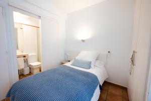 a small bedroom with a blue and white bed at Hostal el Ranxo in Cadaqués