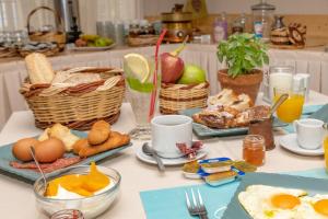 Agali bay hotel في تينوس تاون: طاولة عليها طعام ومشروبات للإفطار