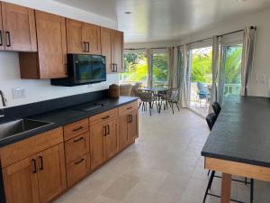 a kitchen with wooden cabinets and a dining room with a table at Kona Tiki Hotel in Kailua-Kona