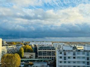 eine Skyline der Stadt mit Gebäuden und einem wolkigen Himmel in der Unterkunft L’appartement du Petit Prince in Vélizy-Villacoublay