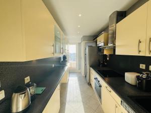 eine Küche mit schwarzen und weißen Schränken und einer Arbeitsplatte in der Unterkunft L’appartement du Petit Prince in Vélizy-Villacoublay