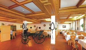 a restaurant with a carriage in a room with tables at Schlossschänke Friedenfels in Friedenfels