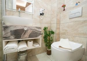 uma casa de banho com um WC branco e um lavatório. em Luxury Medea Taksim Hotel em Istambul