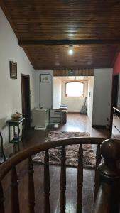 a living room with a wooden ceiling and a room with a table at Hostel do Mirante in Ouro Preto