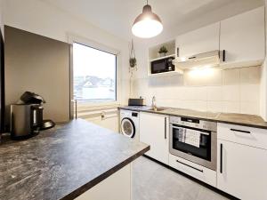 a kitchen with white appliances and a large window at Centerline Apartments Solingen in Solingen