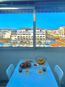 una mesa con comida en ella con vistas a un puerto en T3 Cosy et Confortable à deux pas des Plages, en Sète