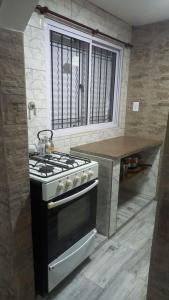 a kitchen with a stove and a counter with a window at Casa Familiar in Mar del Plata +7 photos