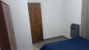 a bedroom with a wooden door and a blue bed at Casa Familiar in Mar del Plata