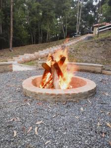 un pozzo di fuoco con due persone sedute dentro di Chales Vinhas da Harmonia a Cunha