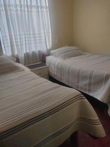 two beds sitting next to each other in a bedroom at MUNAYCHA`S WASI in Cusco