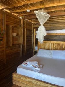 a bedroom with a bed in a wooden cabin at the mompe beach hostal in La Poza